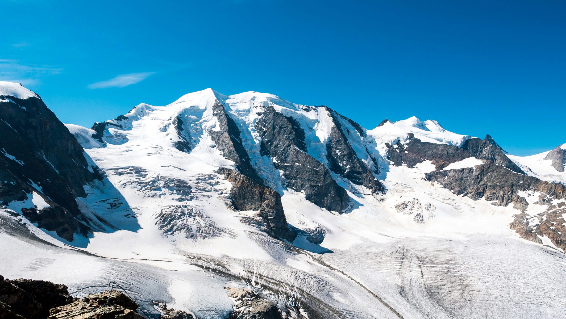 Snow-covered alpine massif under a clear blue sky